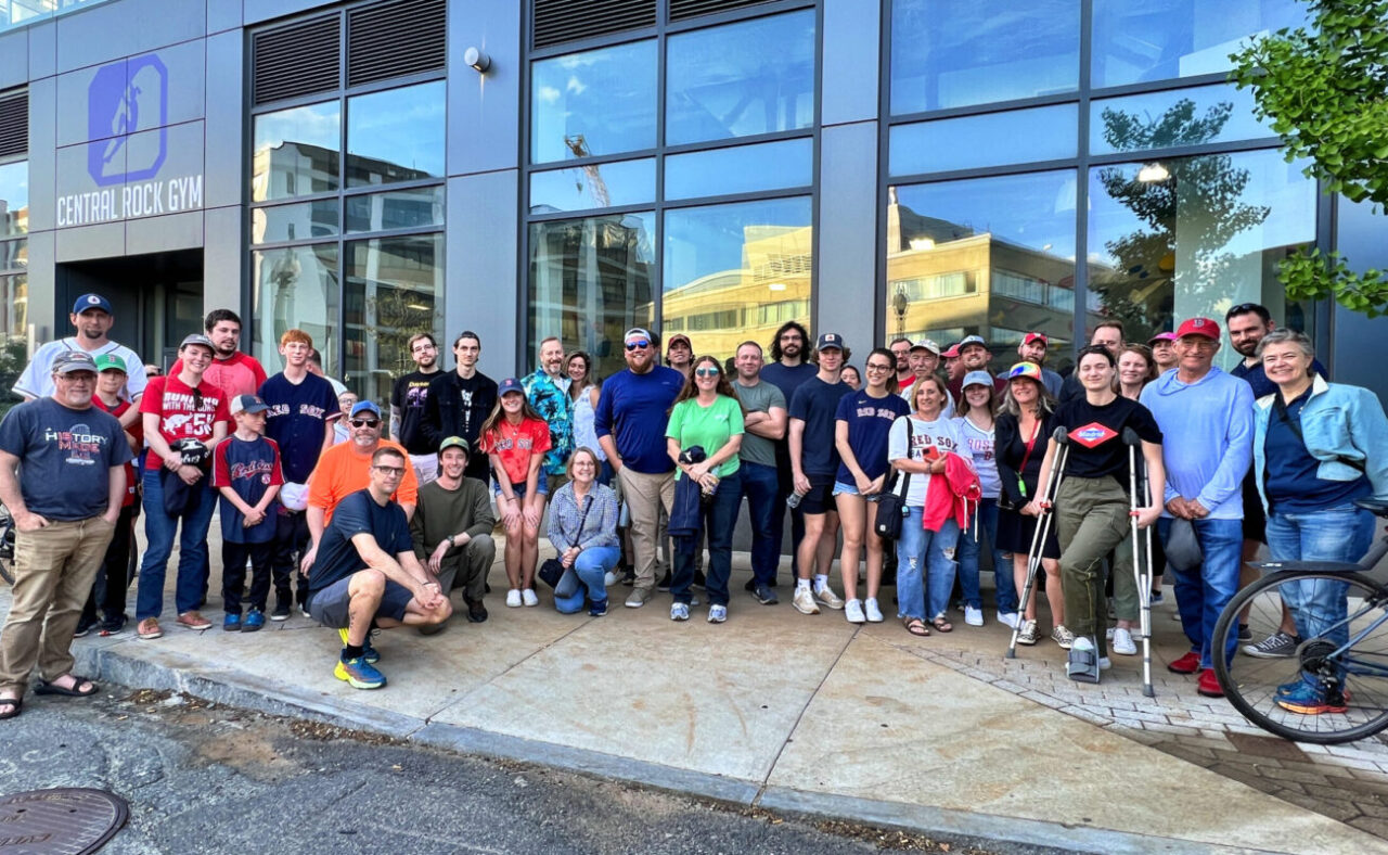 About 40 people pose for group shot standing outside Central Rock Gym