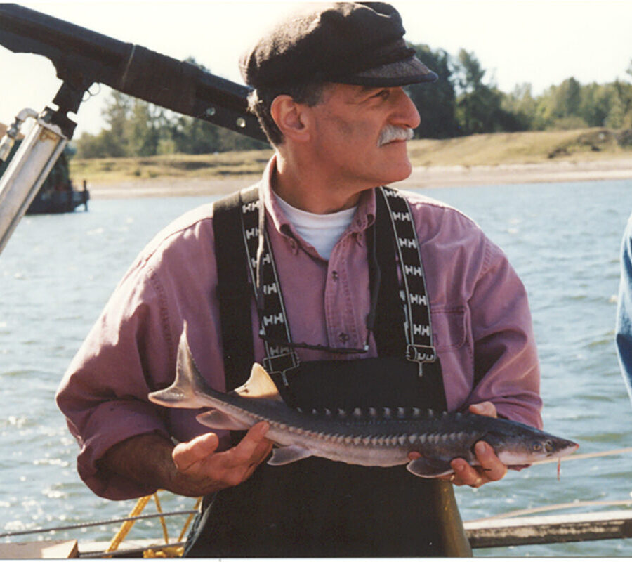 Boat-side photo of a fisherman holding a fish.