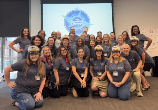 Team photo of over 20 people in a conference room setting.