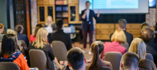 Audience listens to a lecturer at workshop in conference hall
