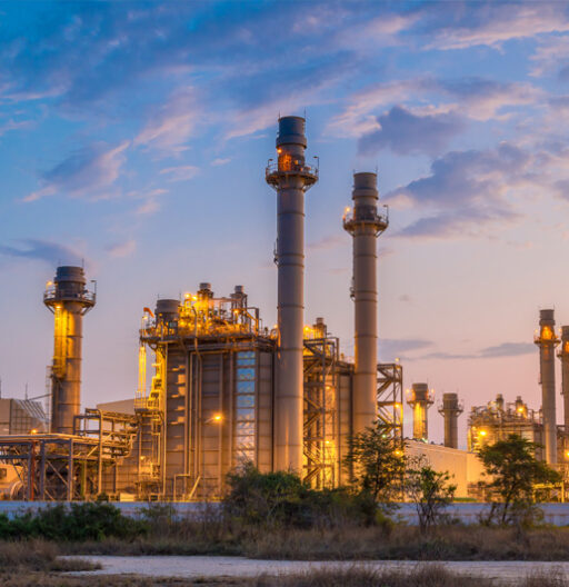 A combined-cycle gas turbine power plant at twilight.