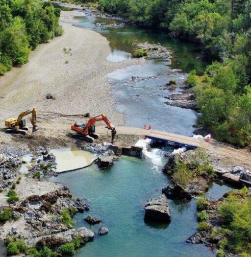 Aerial view of the construction vehicles working to remove a dam.