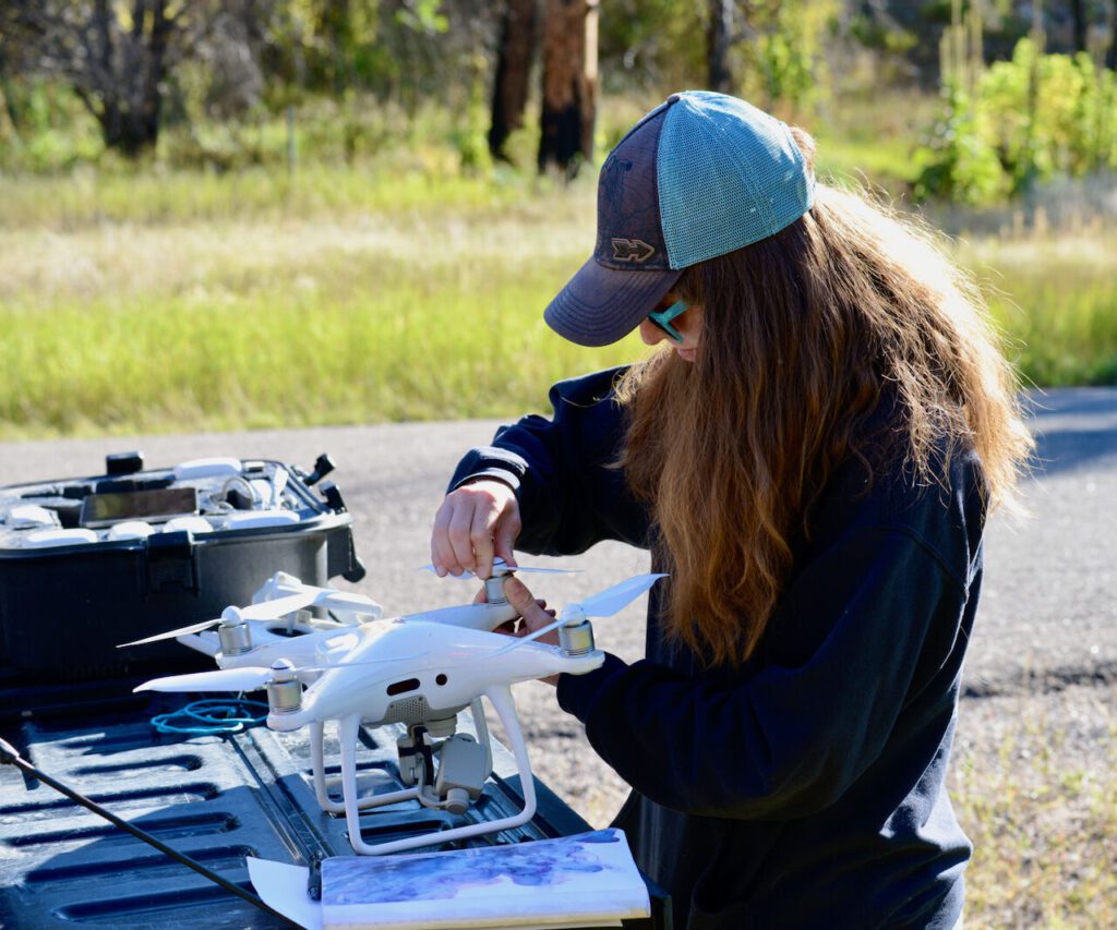 Woman sets up a drone outdoors.