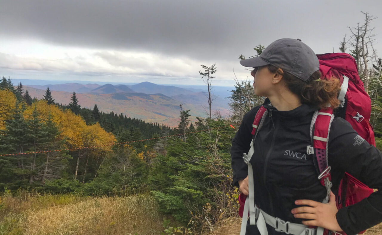 Woman hiker surveys beautiful landscape.