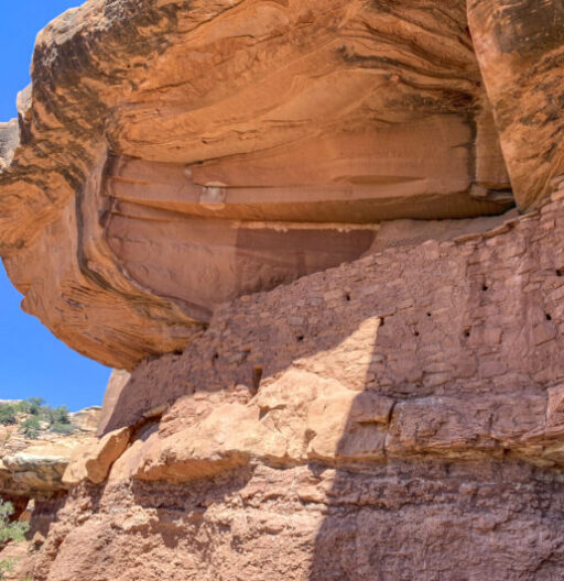 Nature photo of a vertical rock face and rock overhang.