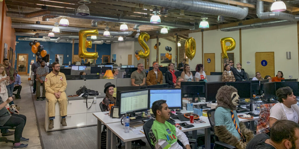 Festive office party snapshot with balloons that spell ESOP.