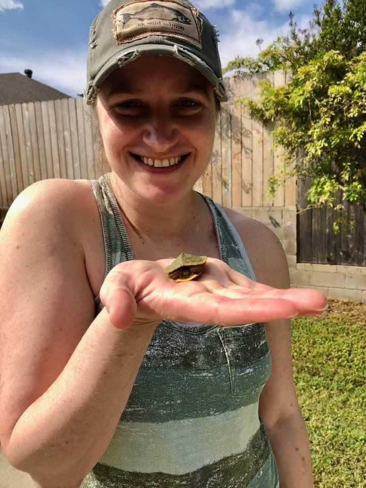 Jayme Fontenot holding a small turtle in her palm. 
