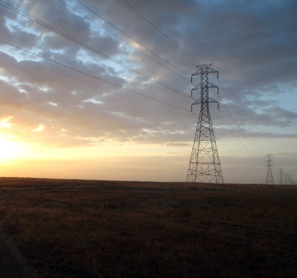 Transmission tower on the horizon at sunset.