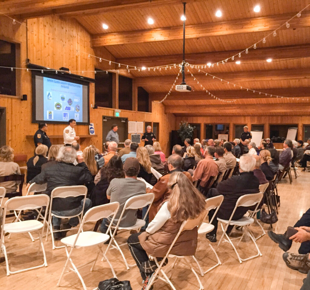 Side view of an audience in folding chairs, attending a meeting at an event center.