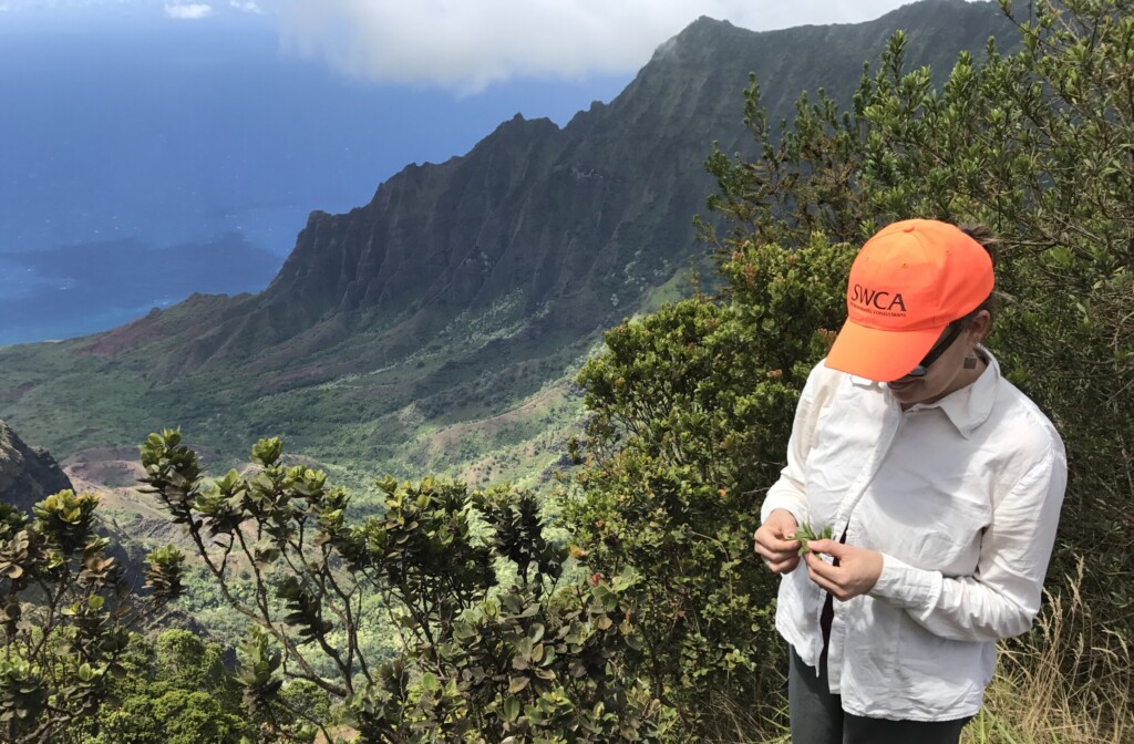 Danielle Frohlich, staff, vegetation, mountains, orange cap, white shirt