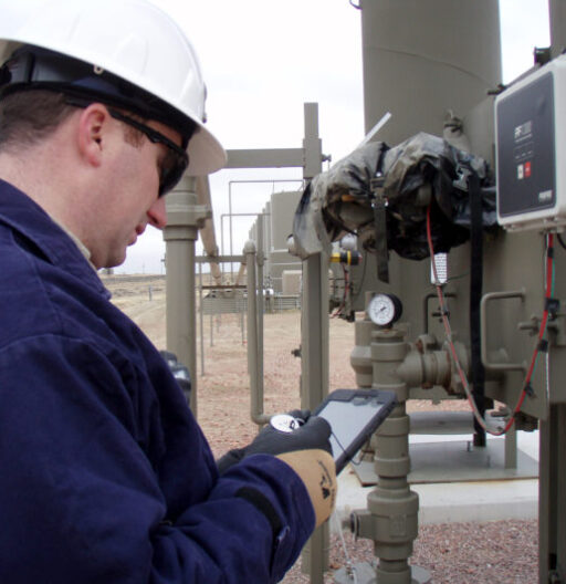 An inspector checks the seal on some outdoor gas pipeline control panel.
