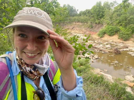 Young woman takes a selfie while hiking near a creek.