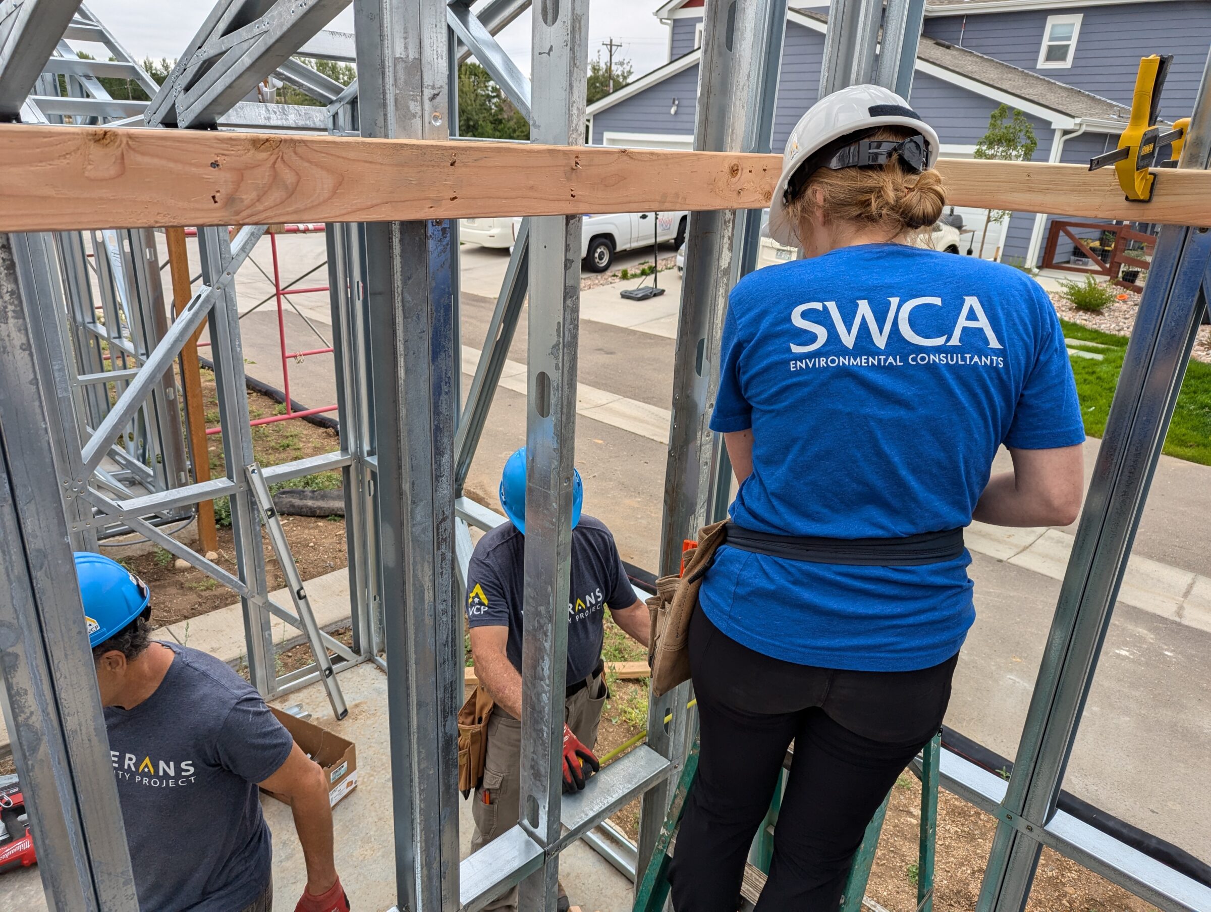 Person in SWCA tee shirt turned away from camera is working at a new home build site.